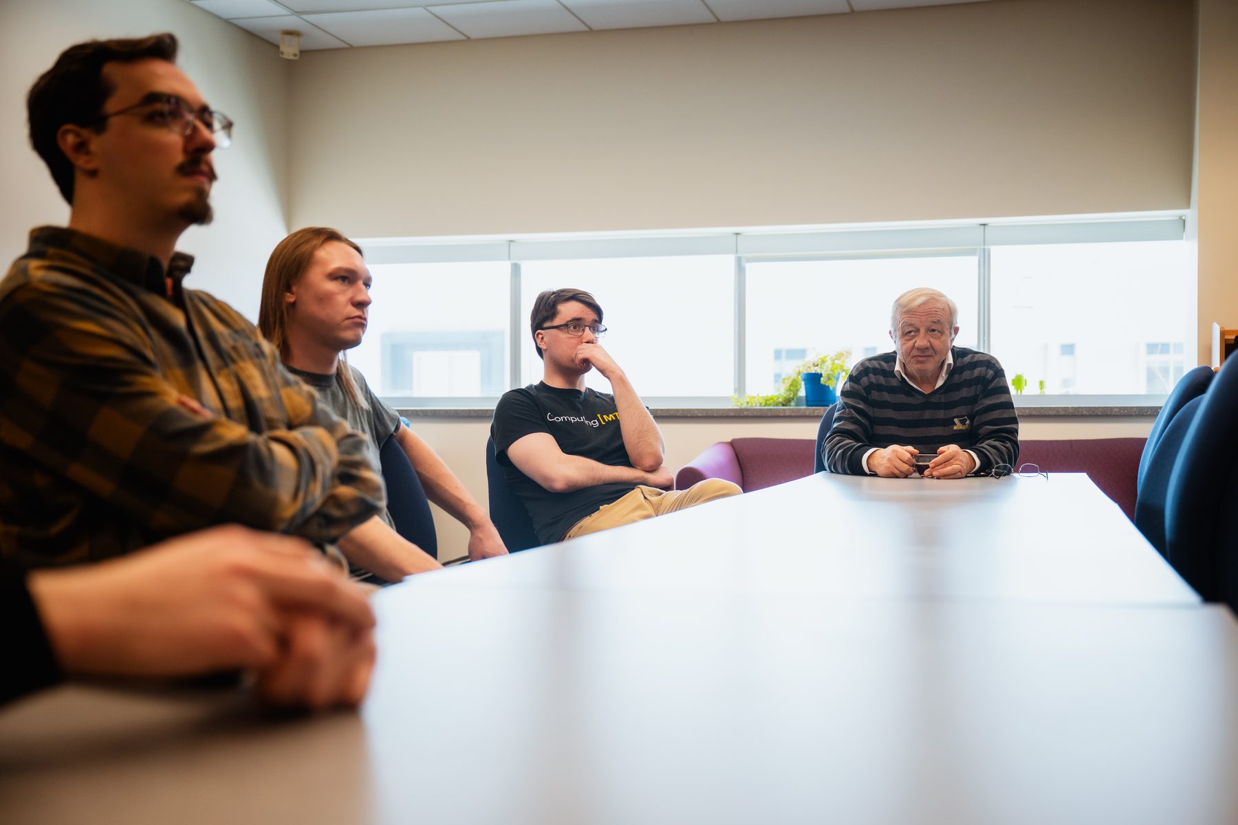 Four members of the SCIA group seated around a conference table during a lab meeting.